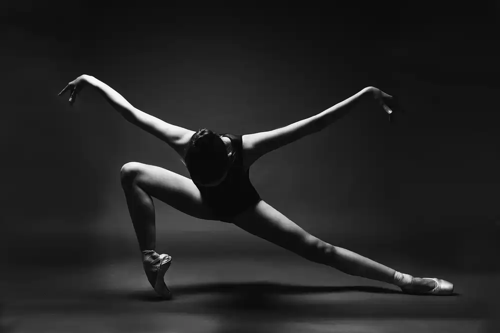 Alexandr: soaring. A ballerina in a pointe shoes in a lunge with her arms outstretched like wings