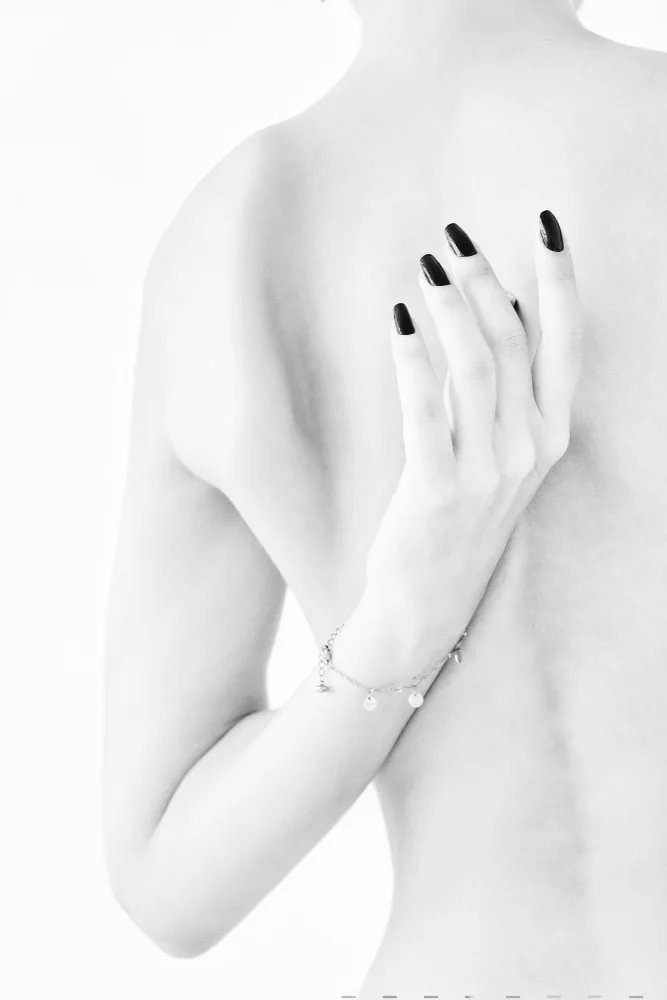 Alexandr: body parts of a naked girl torso and hand pressing her breasts with a black manicure on her nails