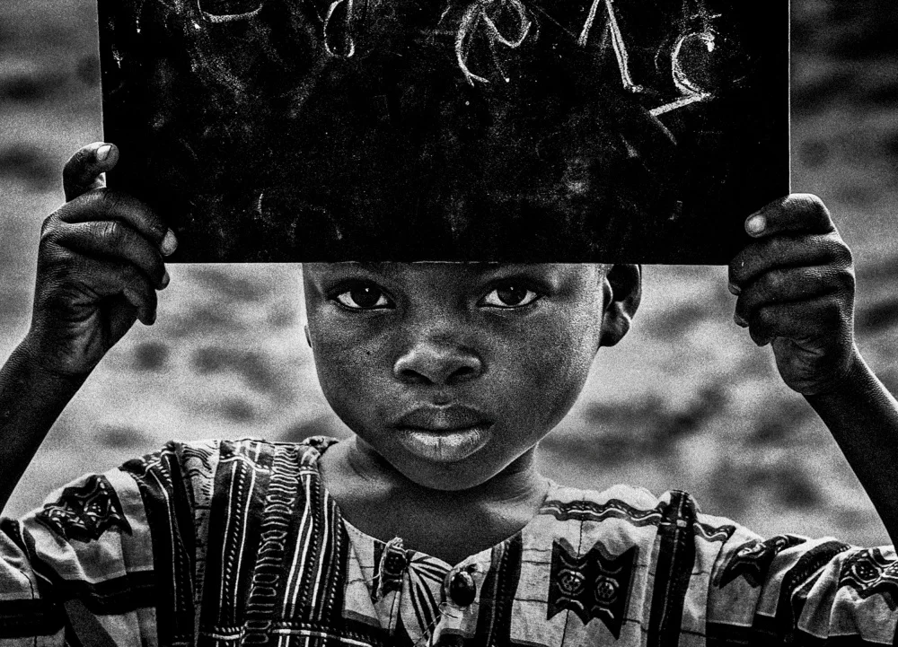 Garmendia, Inazio Joxe: Boy from Benin showing numbers written on the blackboard