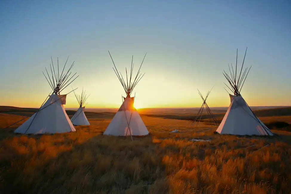 Unknown: Indian teepee at sunrise plains