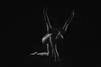 Alexandr: the final time. the ballerina, standing on one knee and leaning forward, spread her arms up