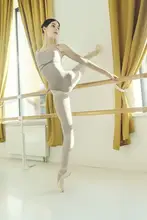 Alexandr: sexy young ballerina standing in a deflection at the ballet machine leaning on it with her hands